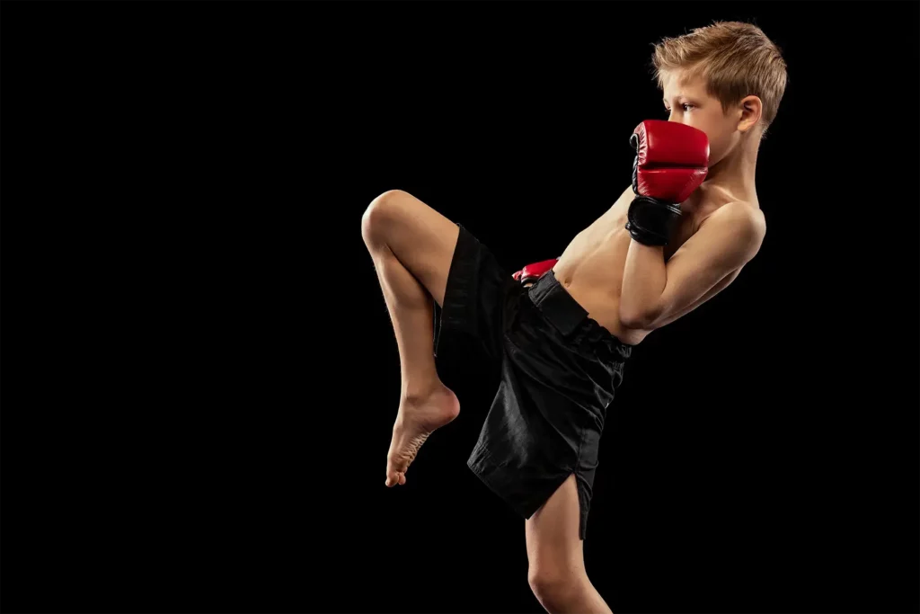 Ein Junge kickt mit dem Knie beim Kickboxen